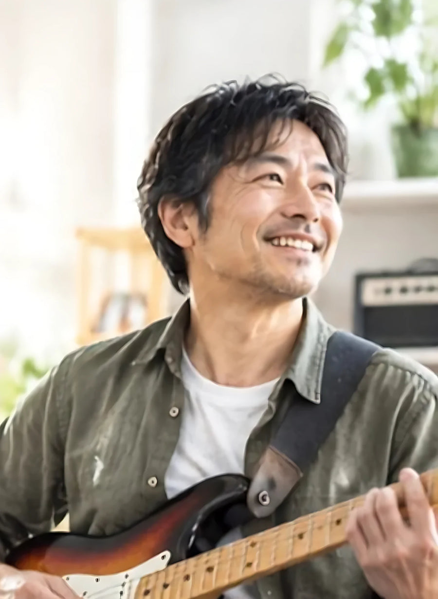 笑顔でギターを弾く男性